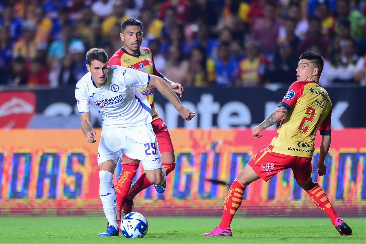 Santiago Giménez sale de la marca de dos jugadores de Morelia y filtra el balón para el cabecita.